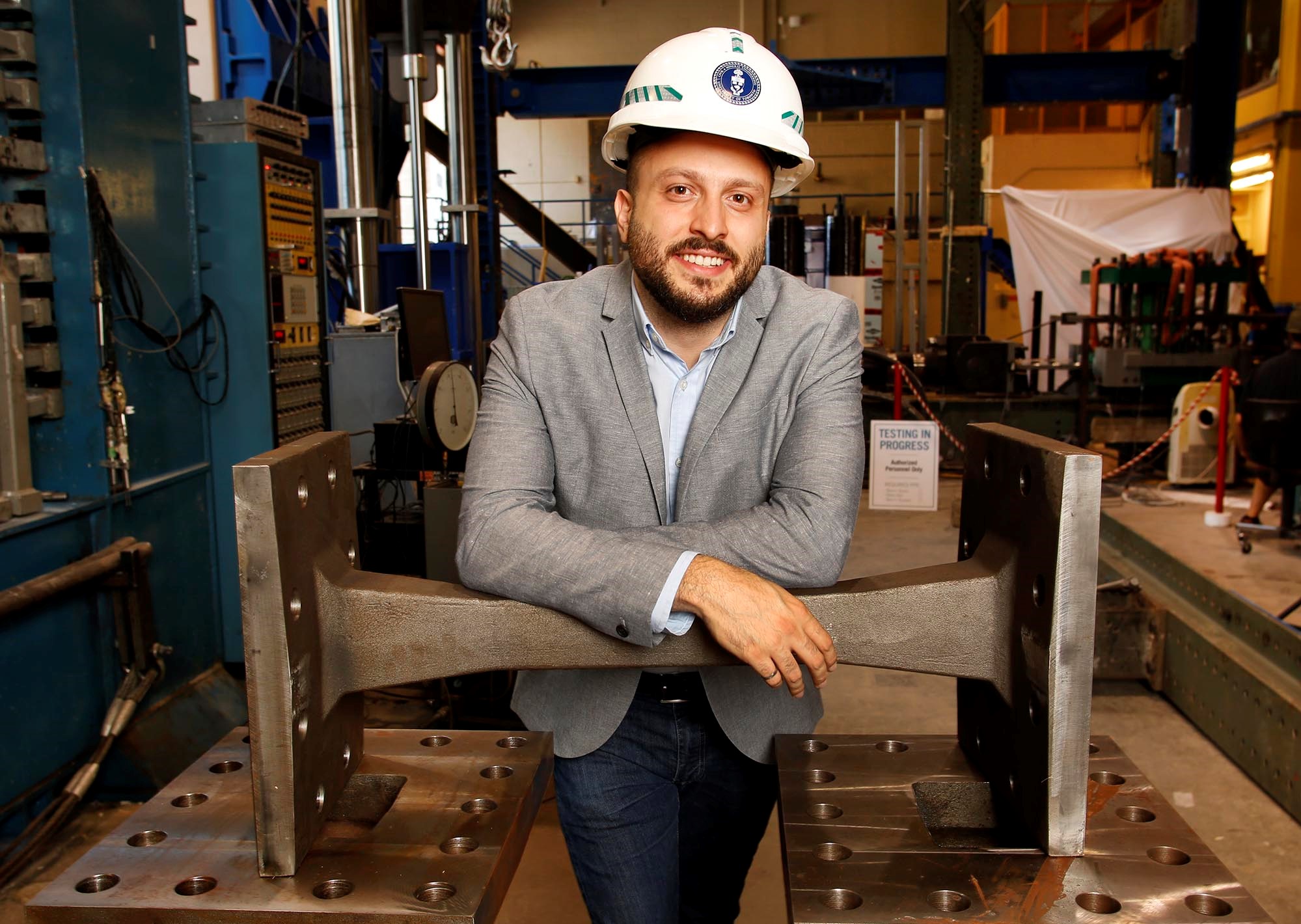 TORONTO: JULY 18, 2019 --  PEDRAM MORTAZAVI -- Civ PhD Candidate Pedram Mortazavi, MASc, P.Eng, poses with a cast steel EBF in the Structures Lab at the University of Toronto's Department of Civil &amp; Mineral Engineering in Toronto on Thursday, July 18, 2019. His thesis is titled: Cast Steel Replaceable Link Elements in Steel Eccentric Braced Frame (EBF), and is designed to allow a specific piece of a building structure fail in an earthquake so as to allow the structure to remain intact. The sacrificial piece is designed to be standardized and replaceable afterwards. 
PHOTO: Phill Snel, Department of Civil &amp; Mineral Engineering/ U of T