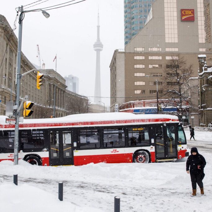 A city bus is pictured stuck since the morning hours in downtown Toronto after a major blizzard dumped as much as 60cm of snow on parts of Southern Ontario, closing major highways and roadways, in Toronto, Ontario, Canada, on January 17, 2022. - Millions across America's east coast and Canada's southeastern provinces hunkered down as a major winter storm continued Monday morning, disrupting travel and cutting power to thousands of homes. (Photo by Cole Burston / AFP) (Photo by COLE BURSTON/AFP via Getty Images)