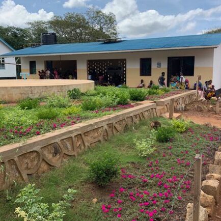 Kharumwa Health Centre in northern Tanzania uses a rainwater harvesting facility: the tank can be seen behind the main building while the solar panel used to power the UV treatment unit is on the roof. (Photo: Karlye Wong)