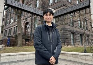 Professor Minghan Xu stands in front of the U of T gates by the Lassonde Mining Building. (Photo by Phill Snel)